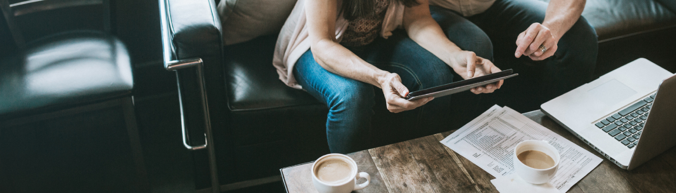 a couple using tablet over coffee