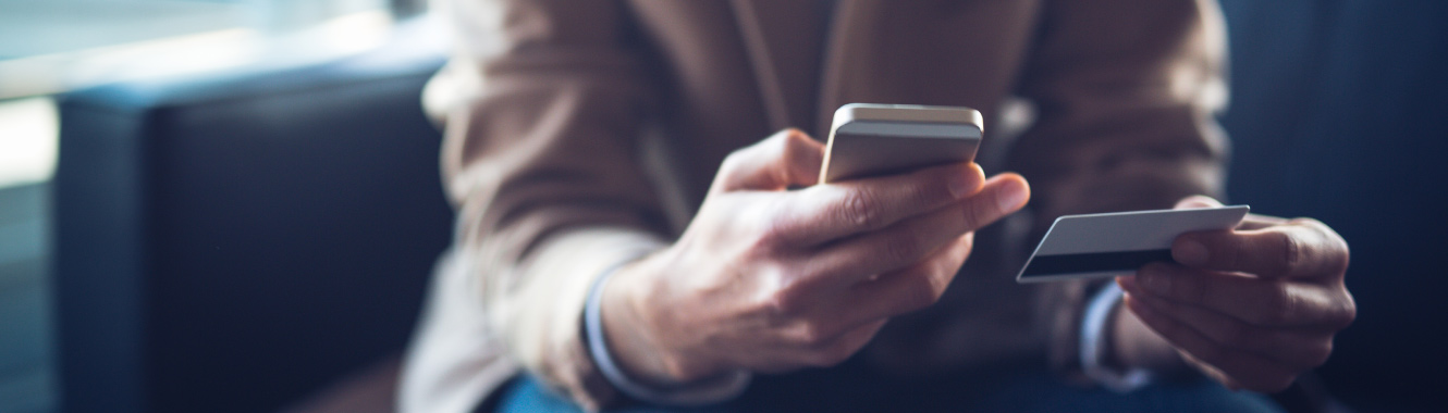 a man holding mobile phone and debit card