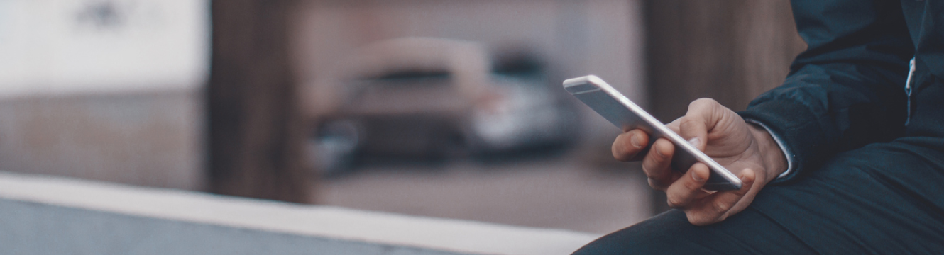 A man sitting outside using his mobile phone